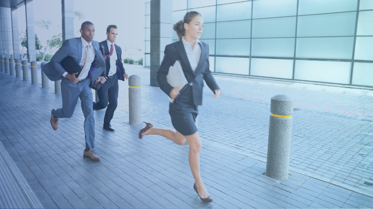 3 people running in office attire outside an office building